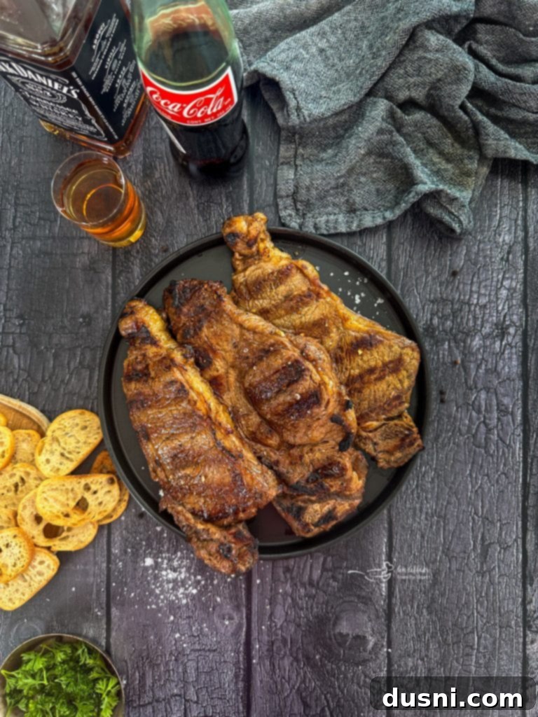 Jack Daniel's and Cola Glazed Steaks 12 Cooked Jack and Coke steaks served on a white platter.