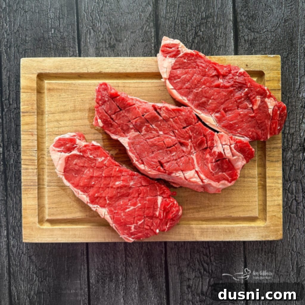 Jack Daniel's and Cola Glazed Steaks 6 Scoring the top of a New York Strip steak with a sharp knife.