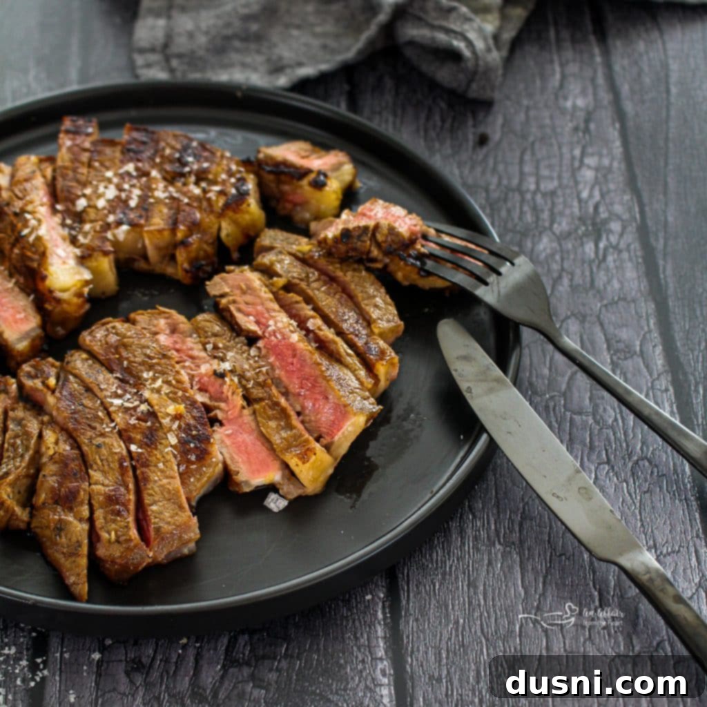 Jack Daniel's and Cola Glazed Steaks 10 Jack and Coke Steaks grilling on an outdoor barbecue.