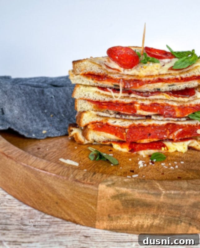 Pepperoni Pizza Grilled Cheese Melt 12 A close-up of a Pepperoni Pizza Grilled Cheese sandwich with a cheese pull, ideal for Pinterest.