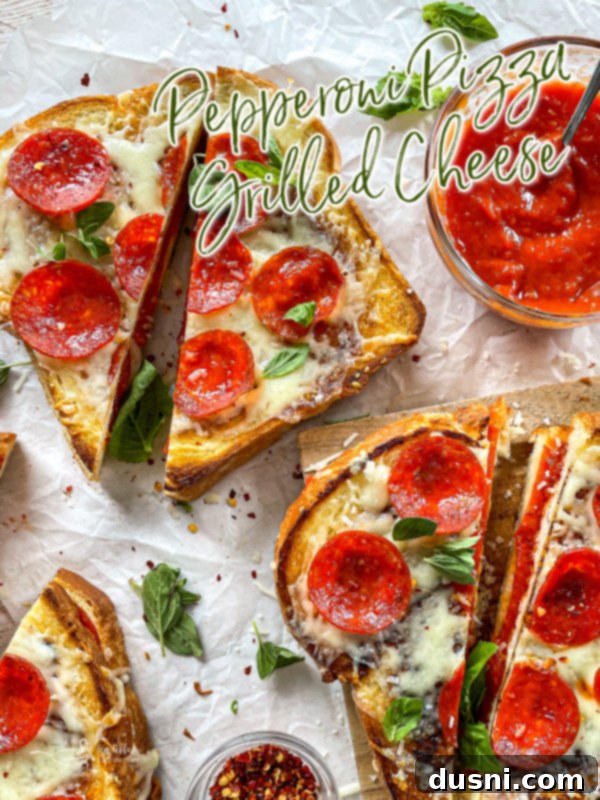 Pepperoni Pizza Grilled Cheese Melt 14 A half-eaten Pepperoni Pizza Grilled Cheese sandwich, showing the gooey melted cheese.