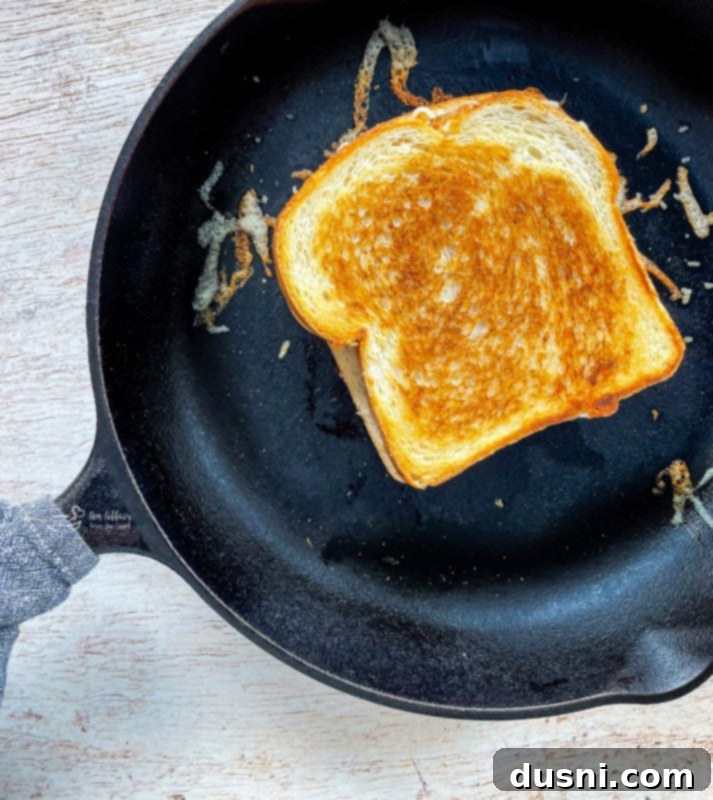 Pepperoni Pizza Grilled Cheese Melt 9 Two pepperoni pizza grilled cheese sandwiches ready for grilling in a cast-iron skillet.