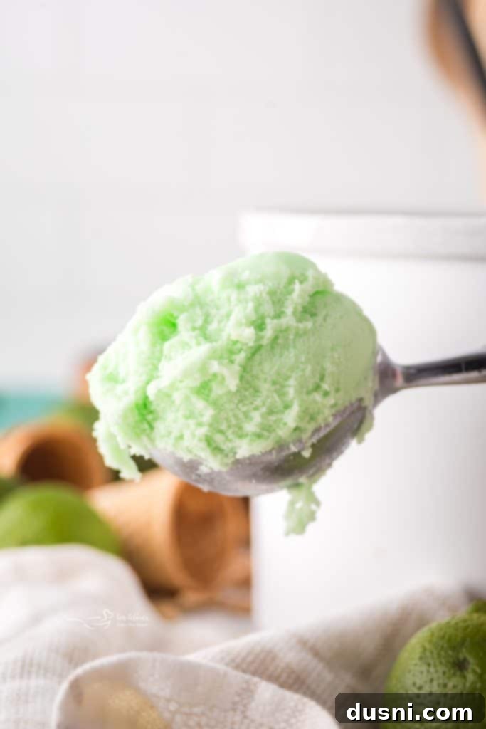 Churned Daiquiri Ice being transferred from the ice cream maker to a freezer-safe container.