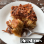 Homestyle Rhubarb Cake 18 Cutting into a piece of Fresh rhubarb cake with a fork.