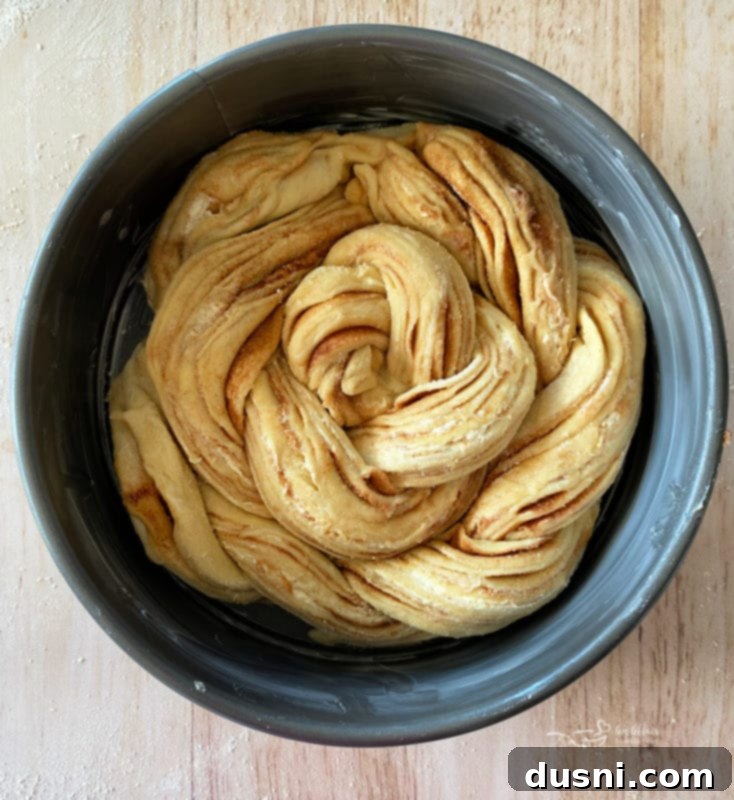 Step-by-step instruction showing the twisted dough coiled into a circular wreath shape for Russian Rose Bread