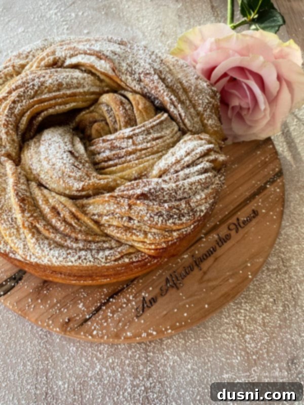 Close-up of baked Russian Rose Bread, showcasing its intricate braided pattern and golden crust on a cutting board
