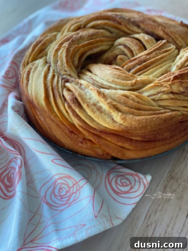 Russian Rose Bread without powdered sugar, showcasing its golden crust and braided texture, resting on a rustic wooden surface