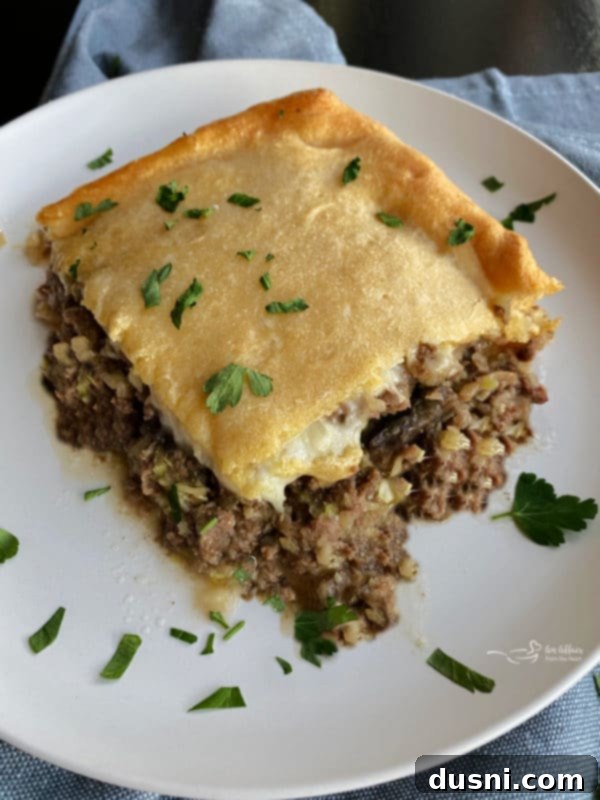 Hearty Swiss Mushroom Runza Bake 2 Swiss Mushroom Runza Casserole slice on a white plate with parsley