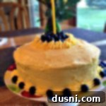 Overhead of Lemonade Cake with Blueberry filling and lemonade butter cream frosting with a candle in it