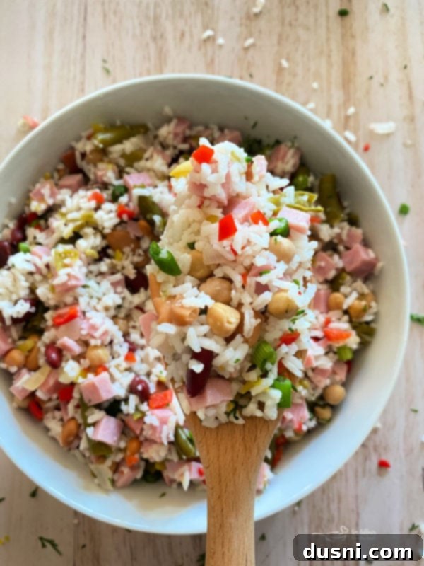 Five Bean Ham and Rice Salad 6 A bowl of Five Bean Ham & Rice Salad served on a rustic table setting.
