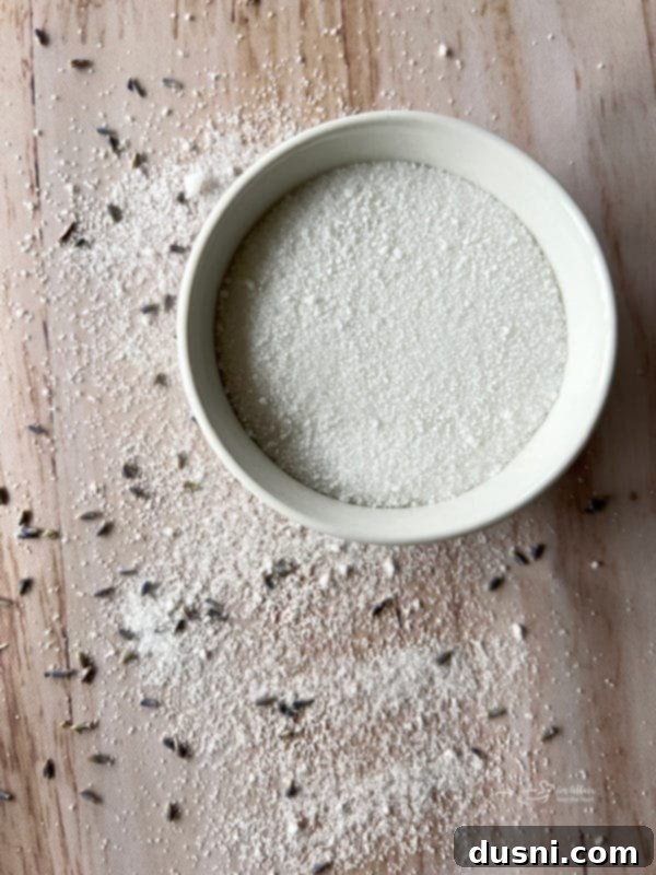 Ekstraktlarla Aromalı Şeker Yapımı 9 A bowl of freshly made flavored sugar with a small wooden spoon, ready for serving or storage.