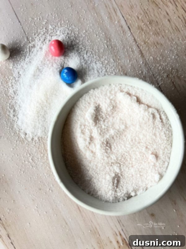 Ekstraktlarla Aromalı Şeker Yapımı 10 Small bowl of lavender flavored sugar with dried lavender buds, next to a spoon.