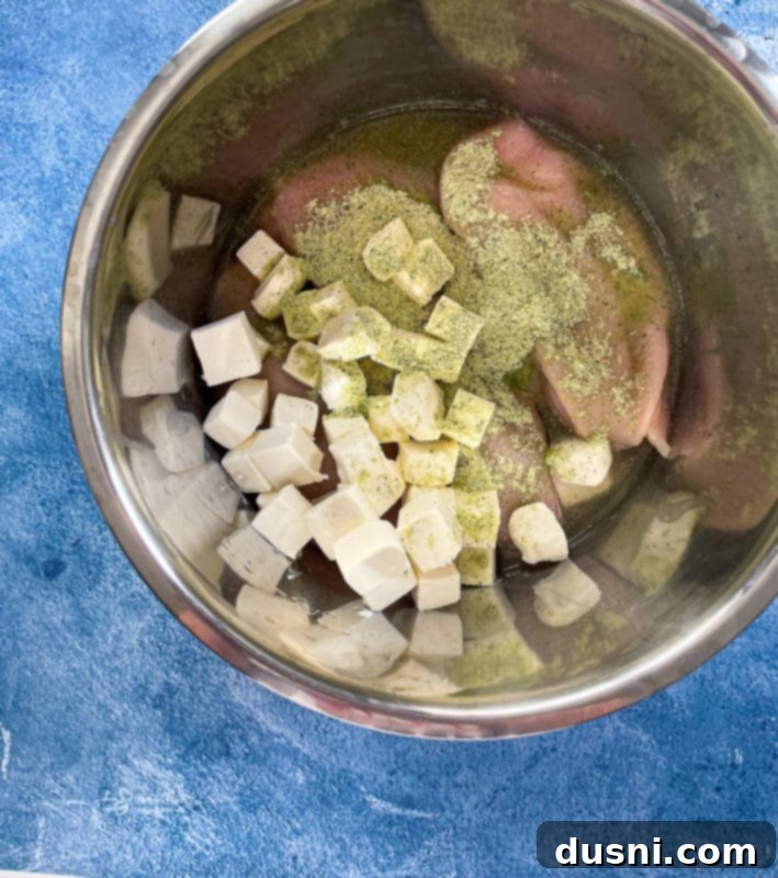 Cubed cream cheese with chicken, chicken broth, and ranch dressing mix
