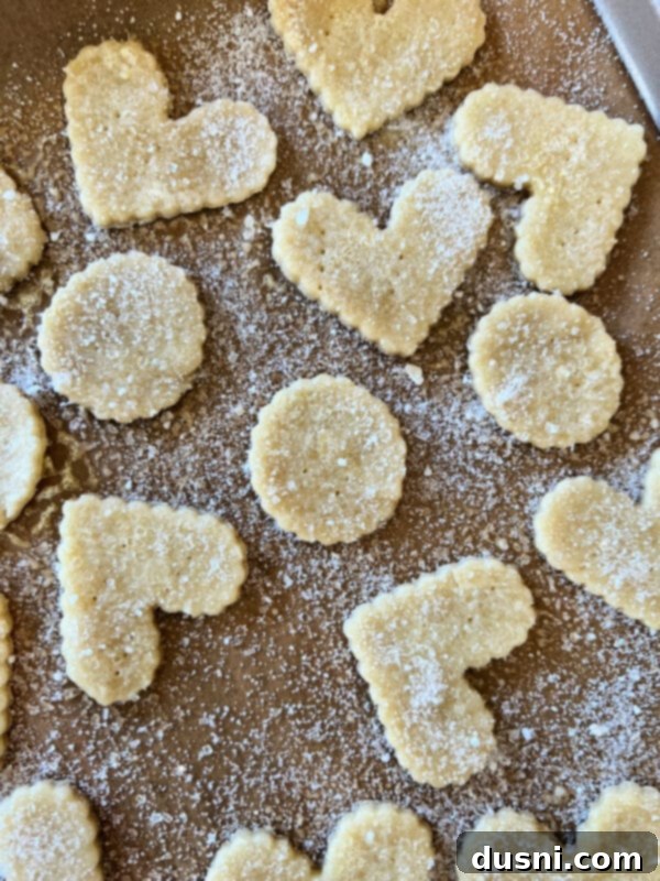 Spraying butter and sprinkling cinnamon sugar on pie crust cookies