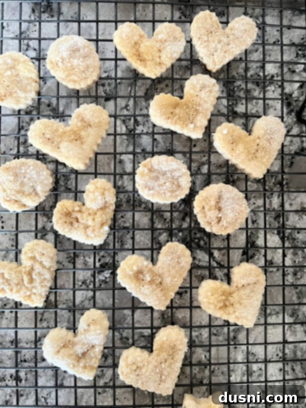 Freshly baked golden brown pie crust cookies on a parchment-lined baking sheet