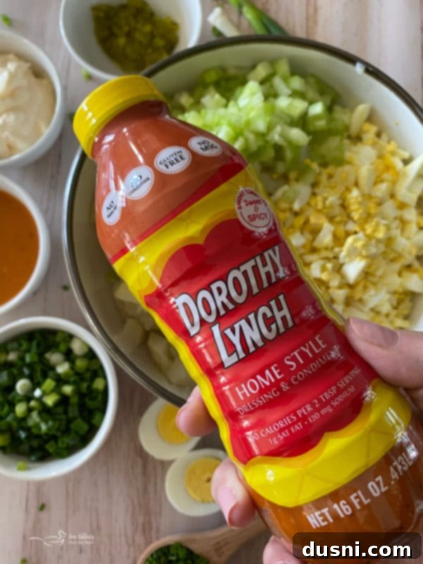A large wooden serving spoon scooping a portion of Dorothy's Homemade Potato Salad from a white bowl, ready to be enjoyed.