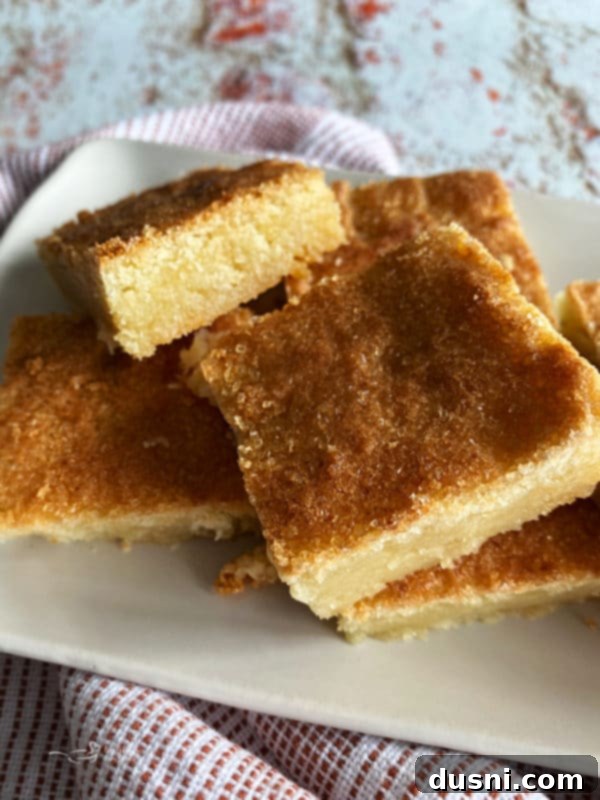 Close-up of a few sliced Dutch Letter Bars on a white plate, revealing the soft interior