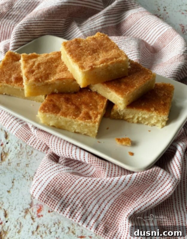 A stack of golden brown Dutch Letter bars on a white plate, showcasing their soft, gooey center