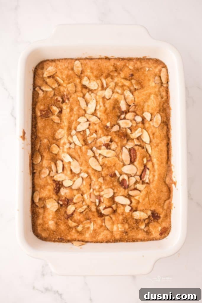 Dutch Letter Bar mixture spread in a baking dish, topped with slivered almonds