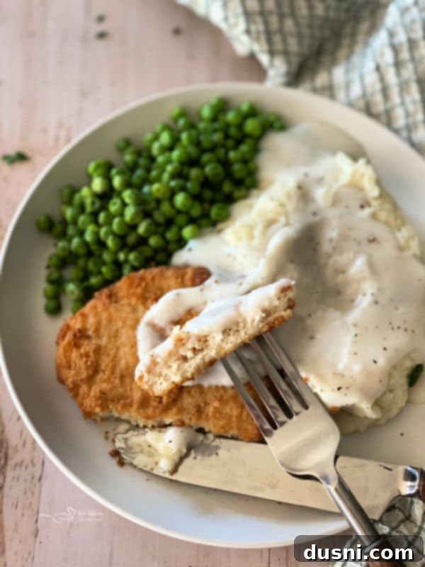 Ultimate Creamy Slow Cooker Mashed Potatoes 17 Family gathered around a dinner table with Southern chicken, mashed potatoes, and peas