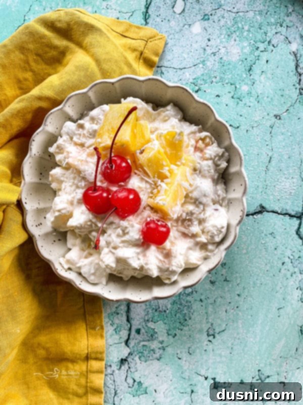 Island Piña Whip 12 Bowl of pineapple fluff with cherries and diced pineapples, close up