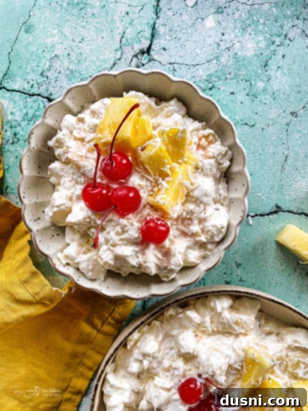 Island Piña Whip 3 Two bowls of fluffy pineapple dessert with cherries and diced pineapple, highlighting its appealing presentation