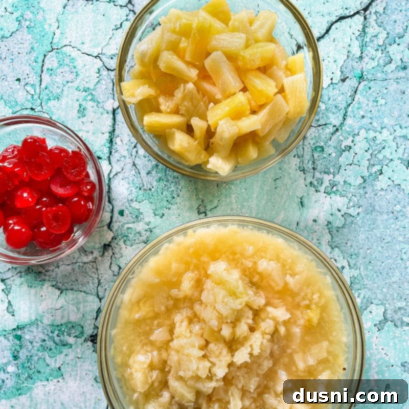Island Piña Whip 4 Sliced pineapple, diced pineapple, and bowl of maraschino cherries – fresh ingredients ready for a tropical recipe