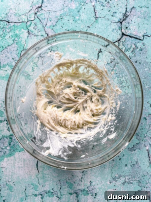 Island Piña Whip 6 Top view of fluffy cream cheese mixture with sugar in a bowl