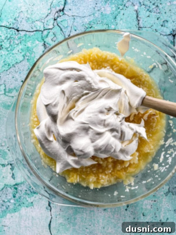 Island Piña Whip 8 Pina Colada fluff mixture and Cool Whip in a clear bowl, ready for folding