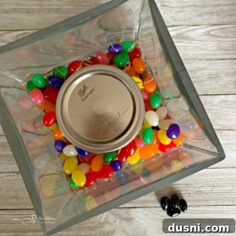 Step-by-step image showing a mason jar being placed into a square glass vase, ready for assembling an Easter Peep Centerpiece.