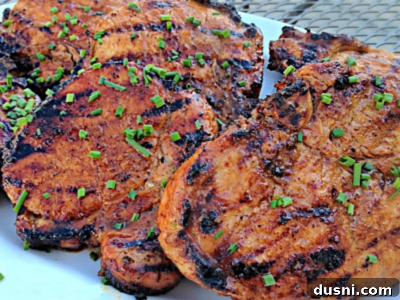 Close-up of apple moonshine glazed pork chops sizzling on a hot grill
