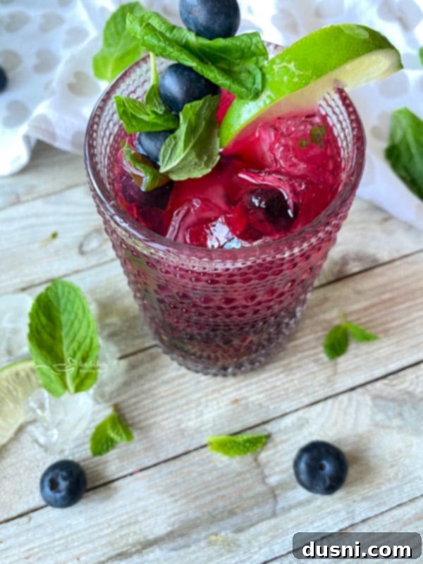 Indigo Berry Refresher 2 Blueberry Mojito cocktail in a glass with mint and lime