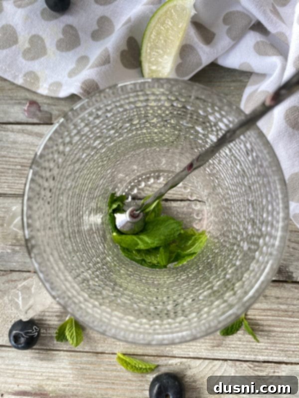 Indigo Berry Refresher 4 Step-by-step image of muddling mint for a Blueberry Mojito