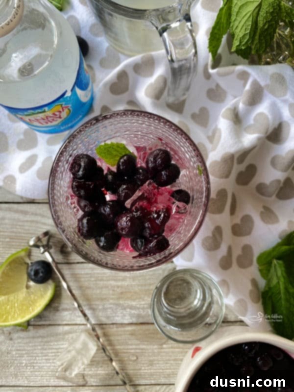 Indigo Berry Refresher 5 Step-by-step image of adding ice, lime juice, and rum to a Blueberry Mojito