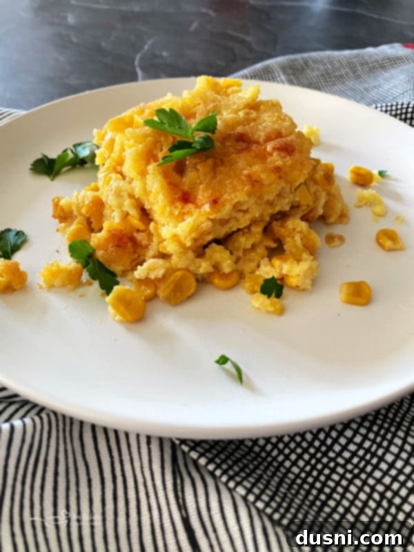 Golden brown corn pie casserole on a white plate, ready to be served