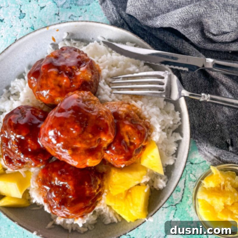 Pineapple Glazed Hawaiian Ham Bites 2 Top view of Hawaiian ham balls in bowl with pineapple chunks and rice