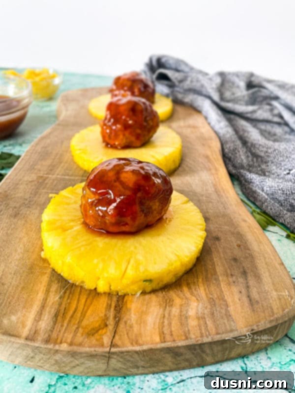 Pineapple Glazed Hawaiian Ham Bites 4 Hawaiian ham balls on top of pineapple slices