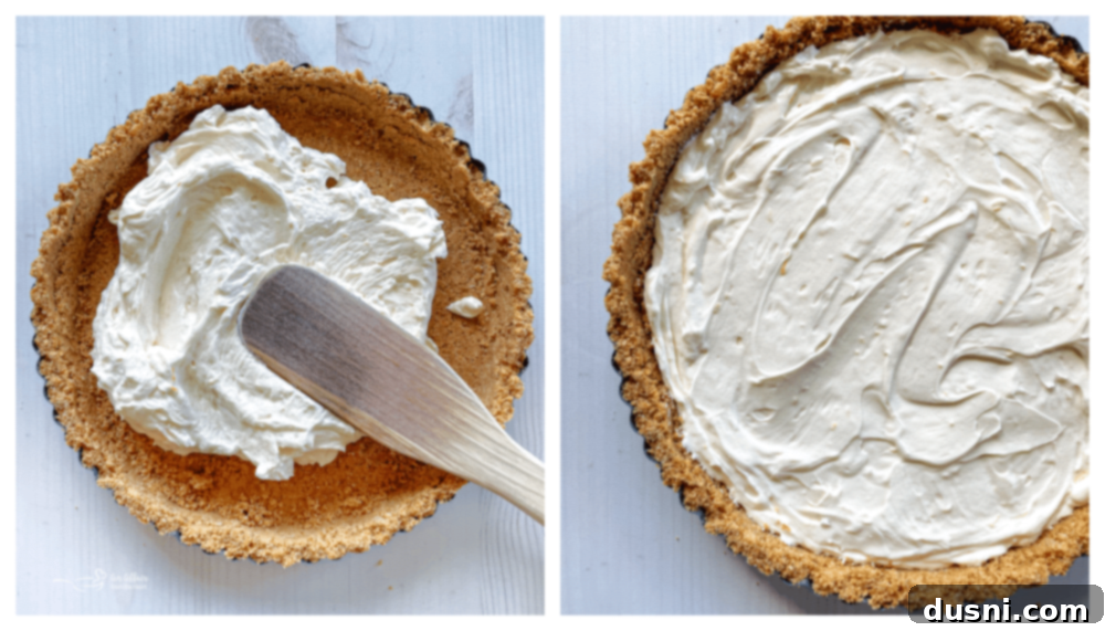 Effortless Fruit Delight 8 cream cheese mixture being spread on graham cracker crumbs