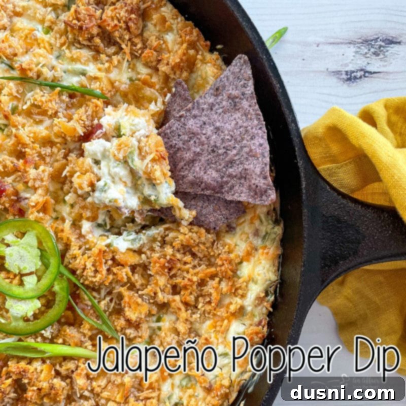 top view of jalapeño popper dip with chip in skillet