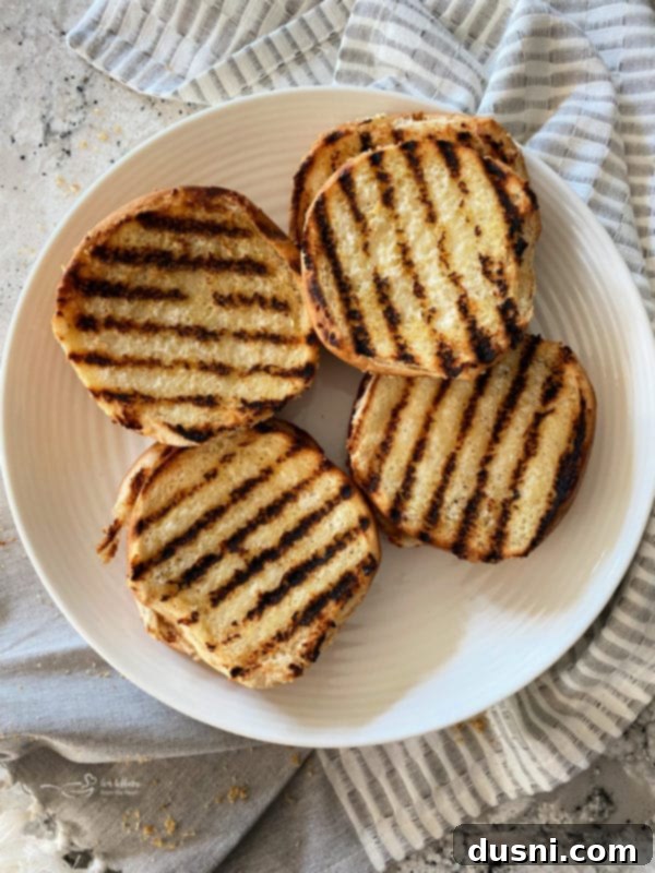 Toasting buttered hamburger buns on the grill