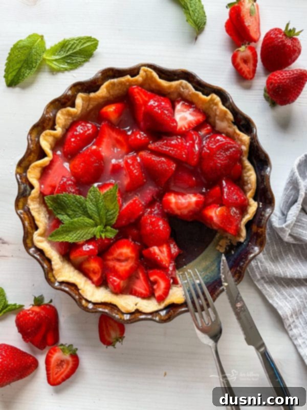 Delicious fresh strawberry pie with mint garnish, viewed from top