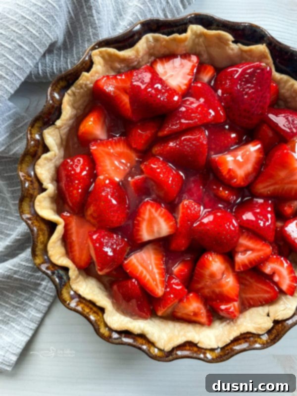 Fresh, glazed strawberries neatly arranged in a pre-baked pie crust