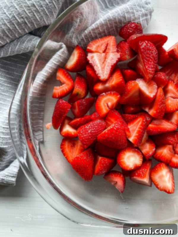 One bowl filled with freshly sliced strawberries, ready for pie filling