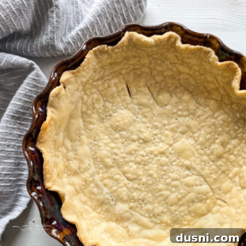 Rolling out pie dough into a circular shape for the crust