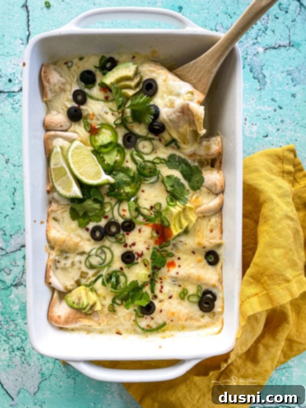 Top view of white chicken enchiladas in white dish 