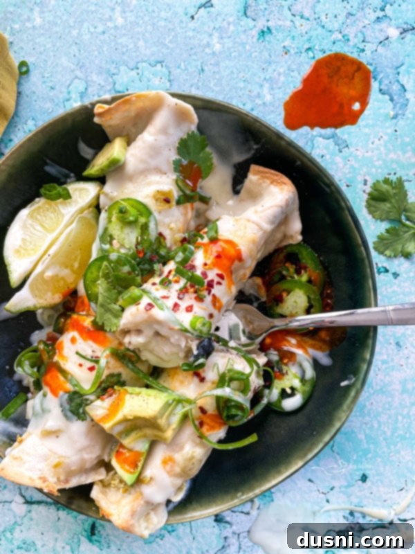 Enchiladas on plate with fork and garnishments