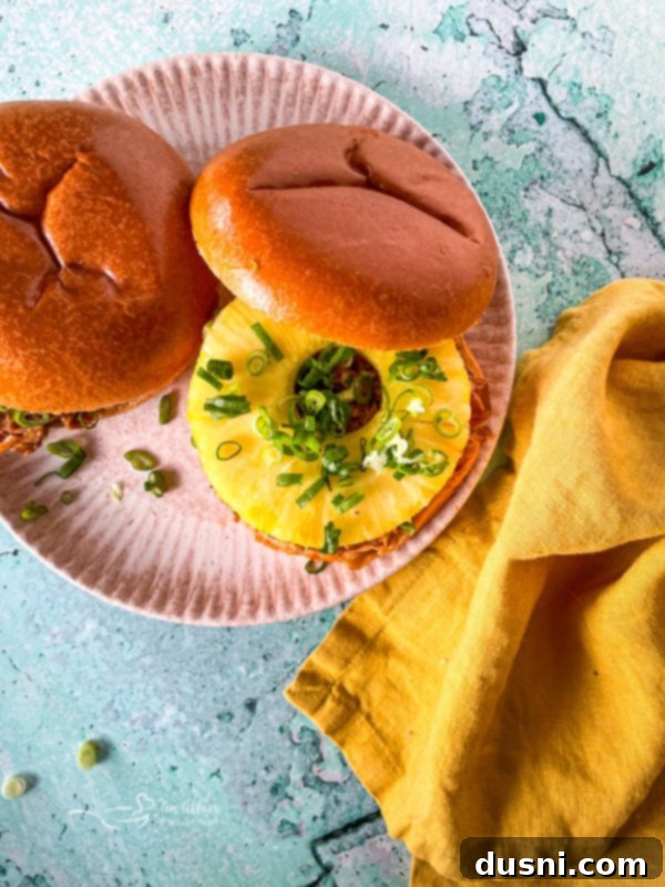 Crockpot Luau Chicken Sandwiches 11 Shredded Hawaiian BBQ chicken coated in sauce in the slow cooker