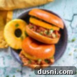 Crockpot Luau Chicken Sandwiches 16 Hawaiian BBQ Pulled Chicken Sandwich on a plate with pineapple