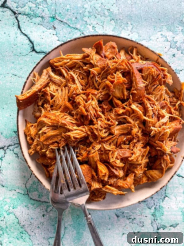 Crockpot Luau Chicken Sandwiches 10 Shredded chicken on a plate, ready to be mixed with thickened sauce