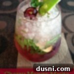 cherry mango mojito in a glass with lime wedge and cherries with text "cherry mango mojito"